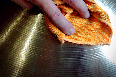 image of a hand polishing a cymbal